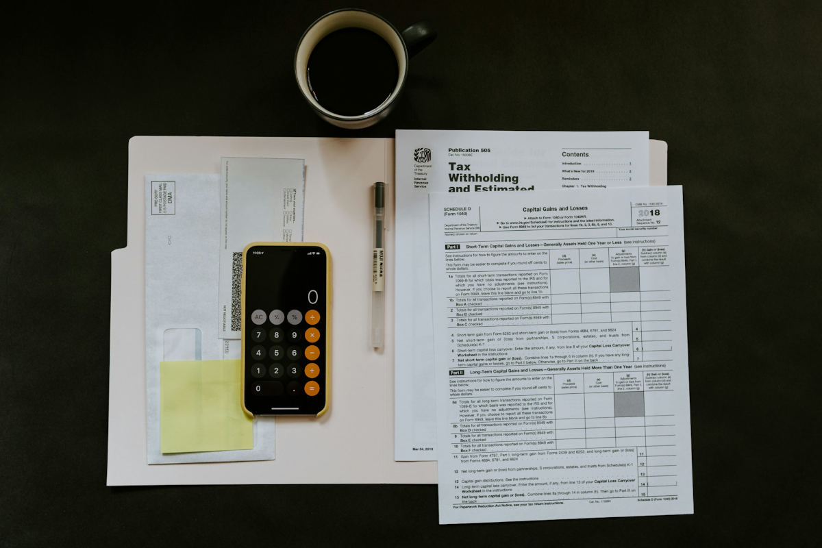 Tax papers and calculator on table next to a coffee mug