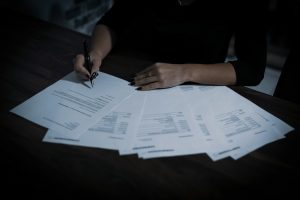 Woman signing papers on a desk