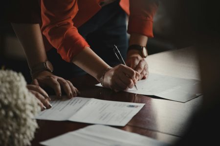 People signing legal documents in an office